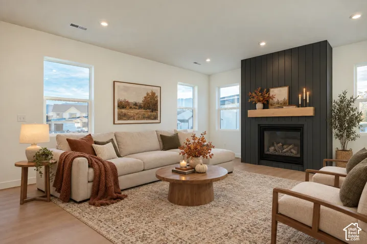 Open-concept living space featuring wood-finish flooring, recessed lighting, and multiple windows
