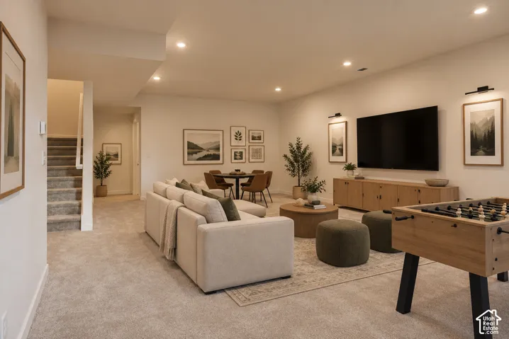 Recessed lighting illuminates a spacious room featuring wall-to-wall carpeting and a neutral color palette