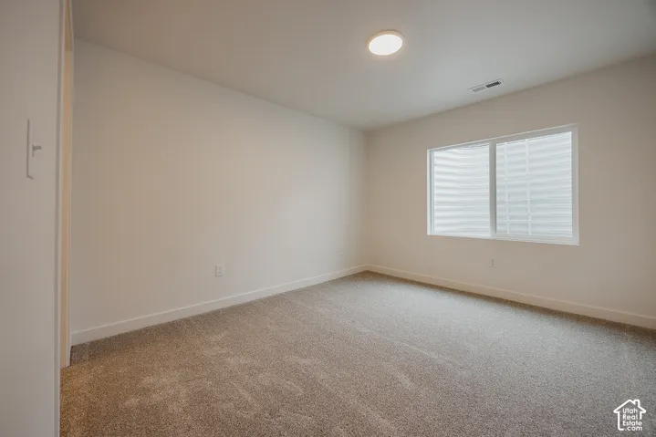 Neutral wall tones, recessed lighting, and soft carpet flooring