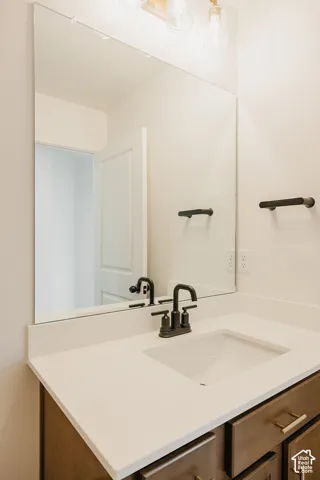 Integrated vanity with a rectangular sink, matte black faucet, and white countertop