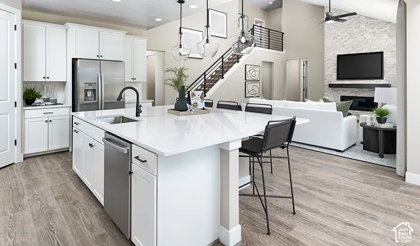 Gourmet kitchen with a large central island, integrated stainless steel appliances, and wood-finish flooring