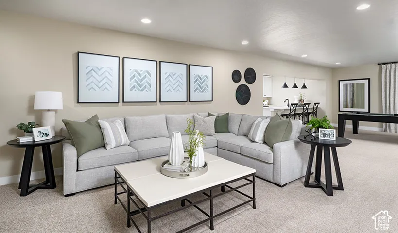 Open-concept living space featuring recessed lighting, light-toned carpeting, and a built-in wet bar with pendant lighting