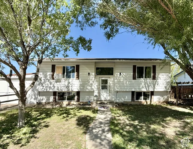 White siding exterior featuring contrasting brown shutters and a prominent front entry door