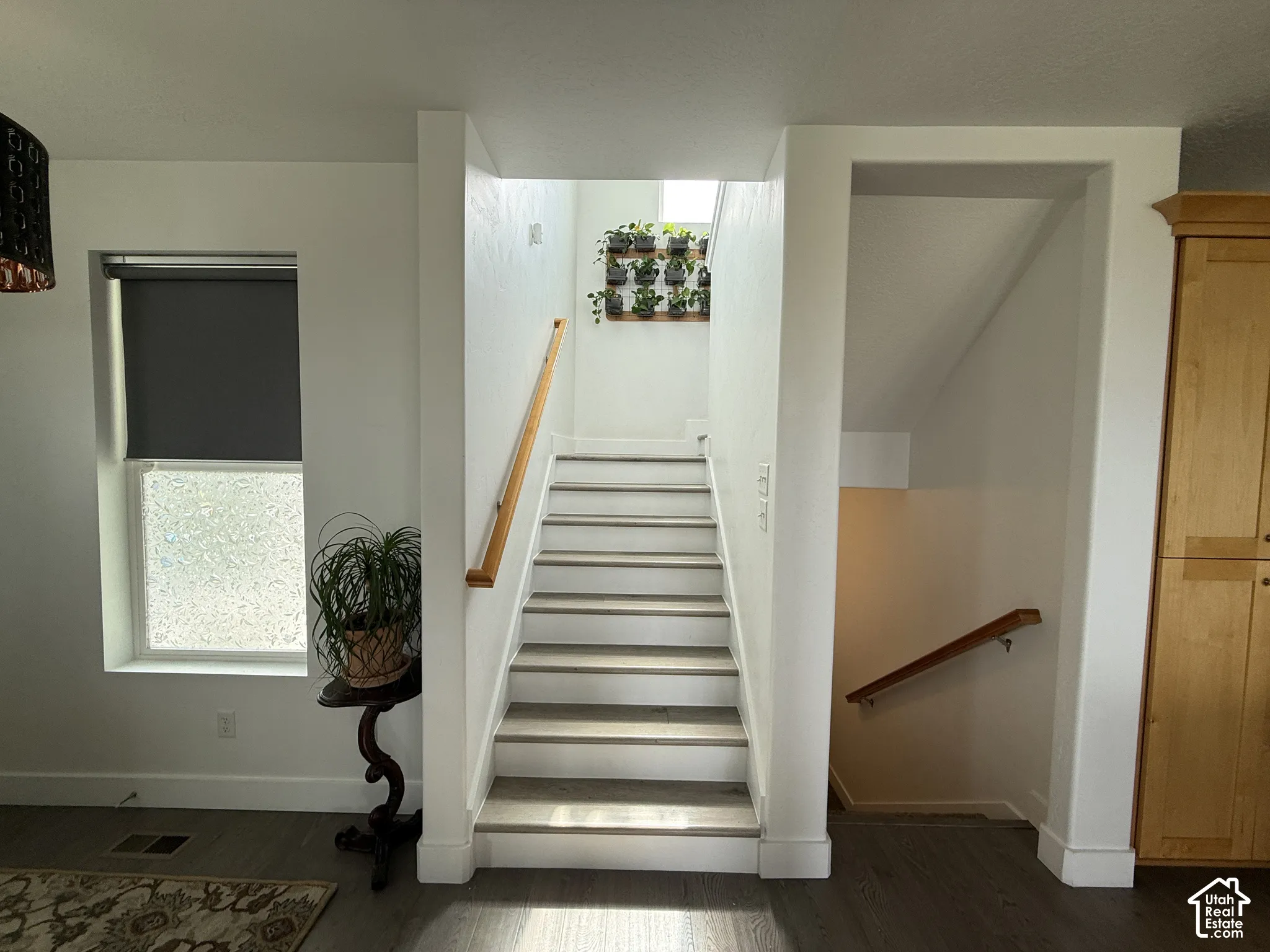 Staircase with light wood handrails and carpeted treads
