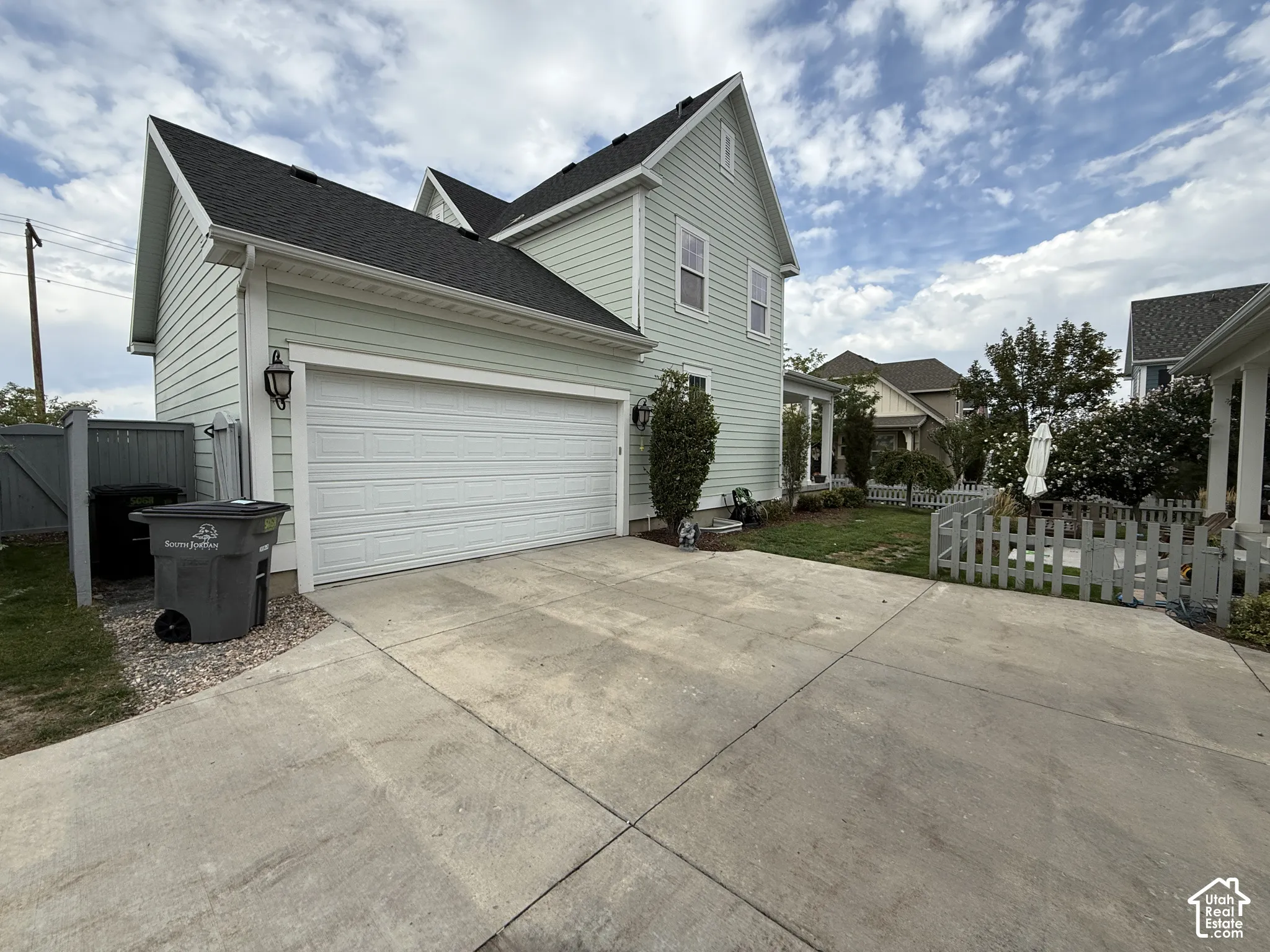 Two-story siding exterior with a pitched roof, attached garage with a panel door, and a concrete driveway