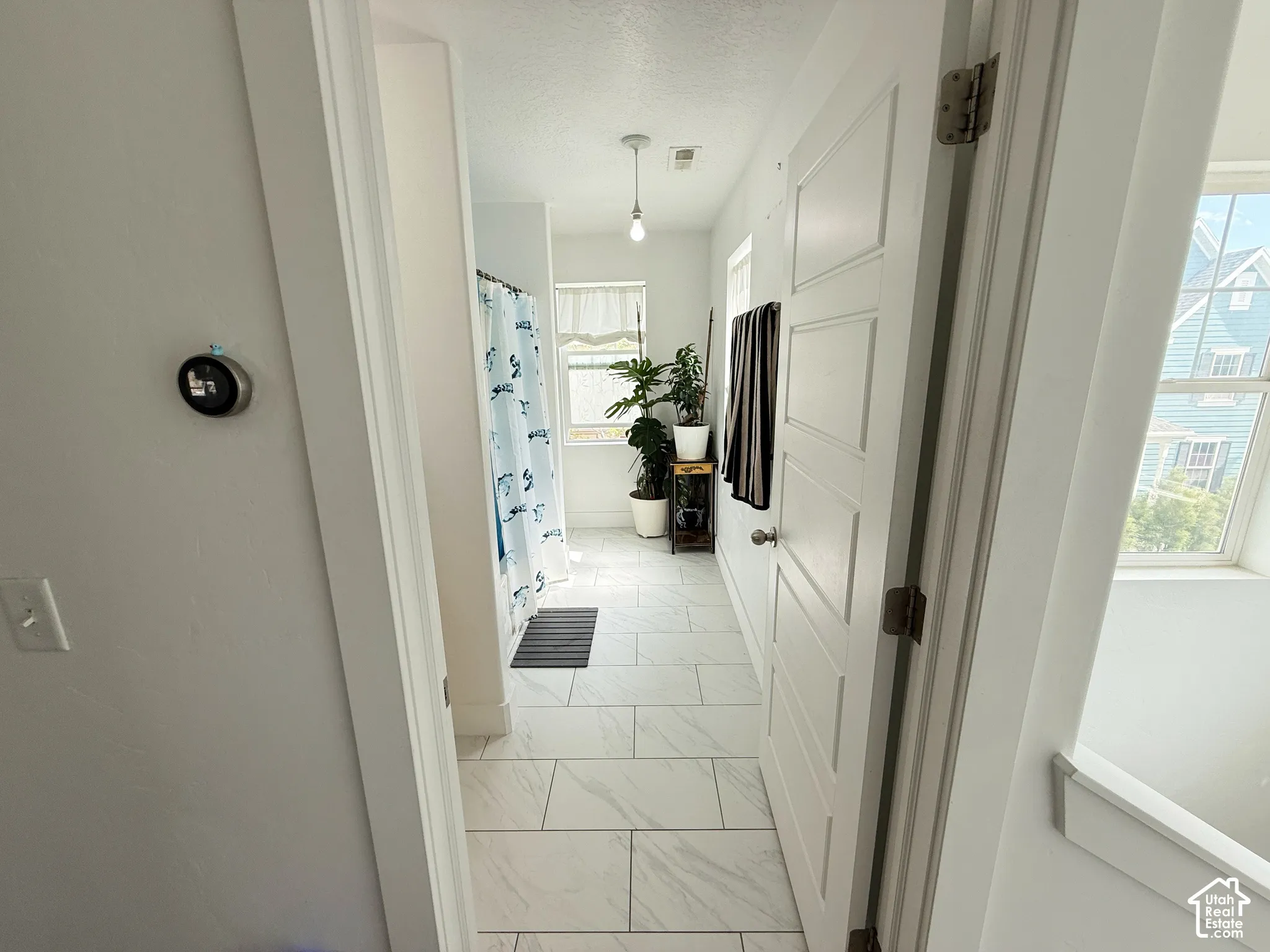 White tile flooring, white walls, and a recessed window