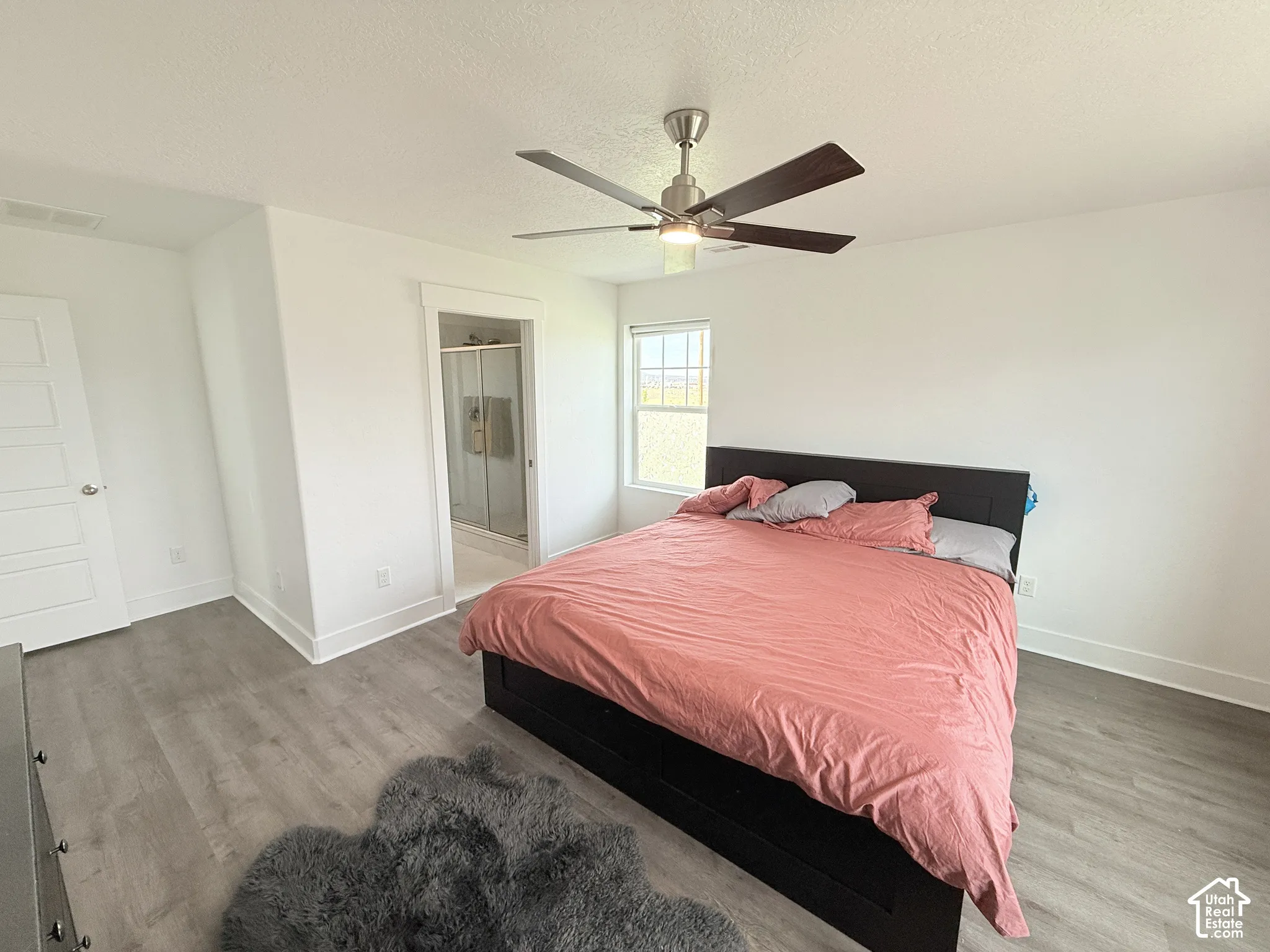 Recessed window, wood-finish flooring, ceiling fan with integrated lighting, white trim, and a glass-enclosed shower