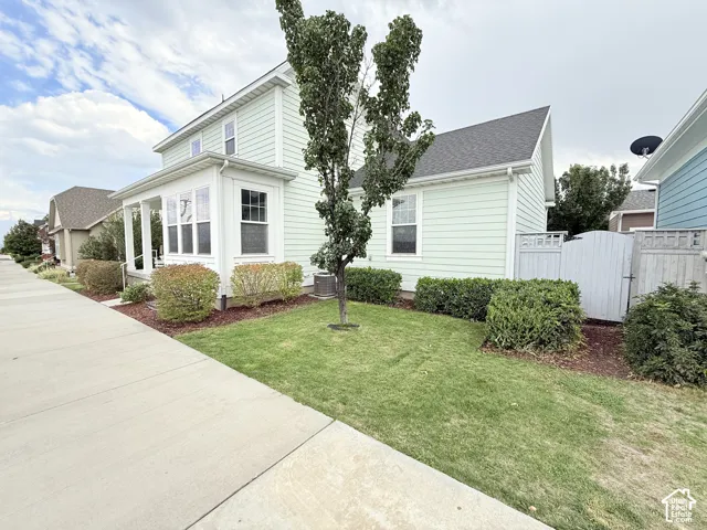 Light green horizontal siding exterior with a covered front porch and multi-pane windows