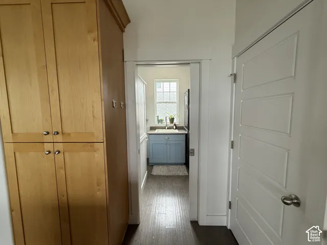 Built-in wood-finish cabinetry, five-panel interior door, and wood-finish flooring