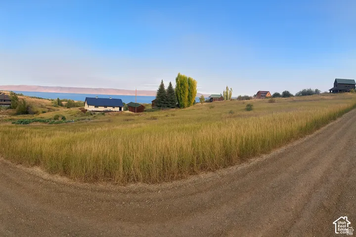 Spacious undeveloped lot featuring a prominent slope and established perimeter trees