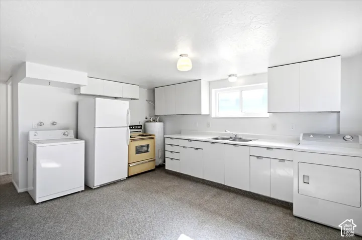 White cabinetry with integrated handles, double basin sink, and a window with a white frame
