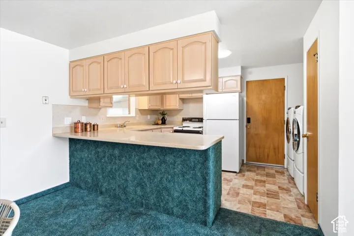Kitchen featuring wood-finish cabinetry, light-toned countertops, and a full suite of white appliances