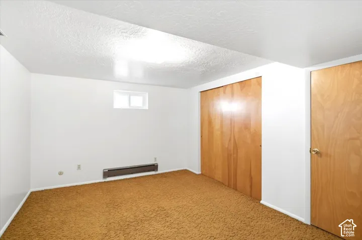 Wall-to-wall carpeting with light-toned walls and ceiling
