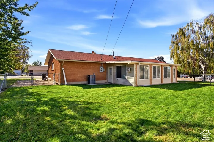 Expansive green lawn with mature trees and a fenced area