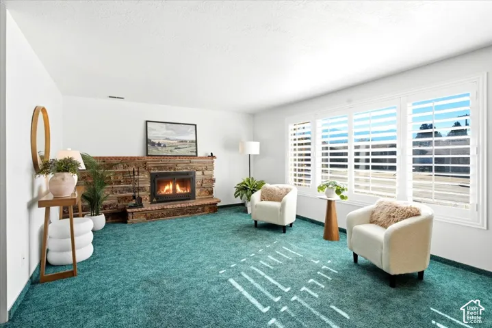 Brick and stone fireplace with a raised hearth, large windows, and plantation shutters