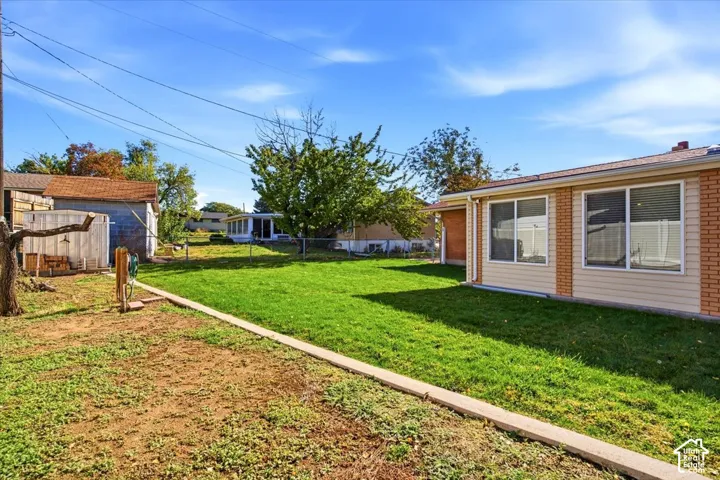 Expansive exterior featuring a manicured lawn, an established tree, and a concrete walkway