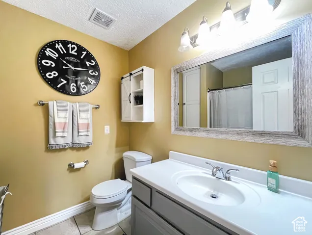 Vanity with white countertop, chrome faucet, and gray cabinetry
