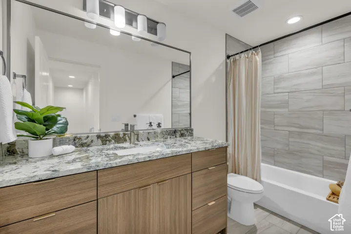 Dual-sink vanity with wood-finish cabinetry and a speckled countertop