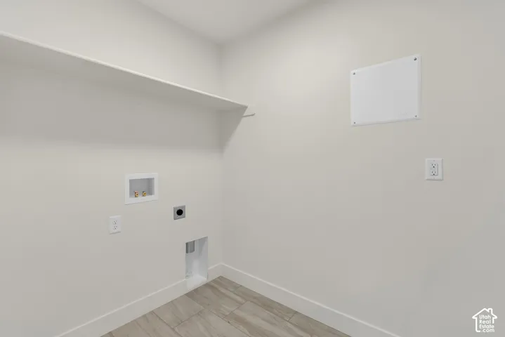Utility room featuring a built-in shelf, neutral wall tones, and wood-finish flooring