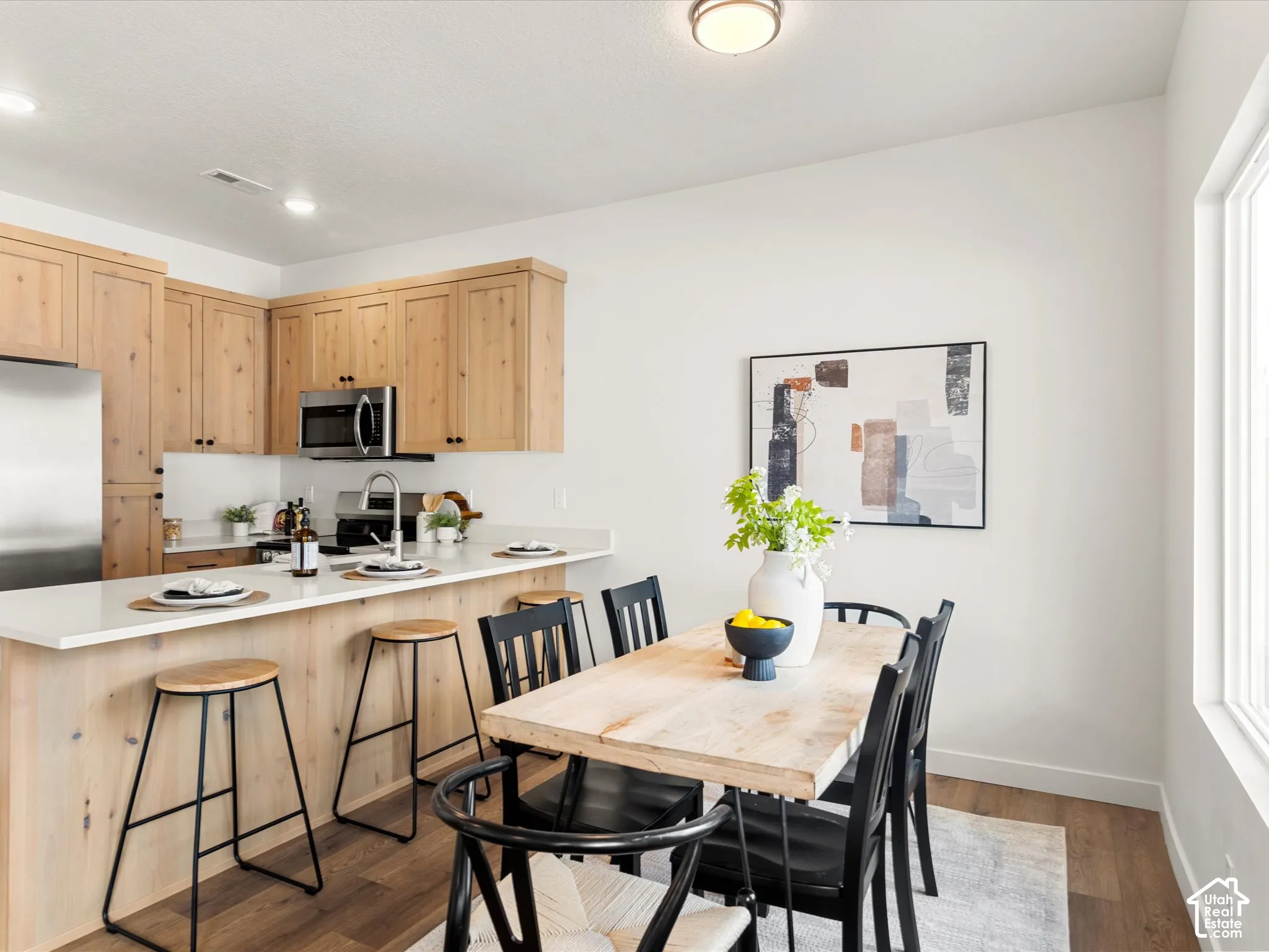 Kitchen with wood-finish cabinetry, stainless steel appliances, and a white countertop
