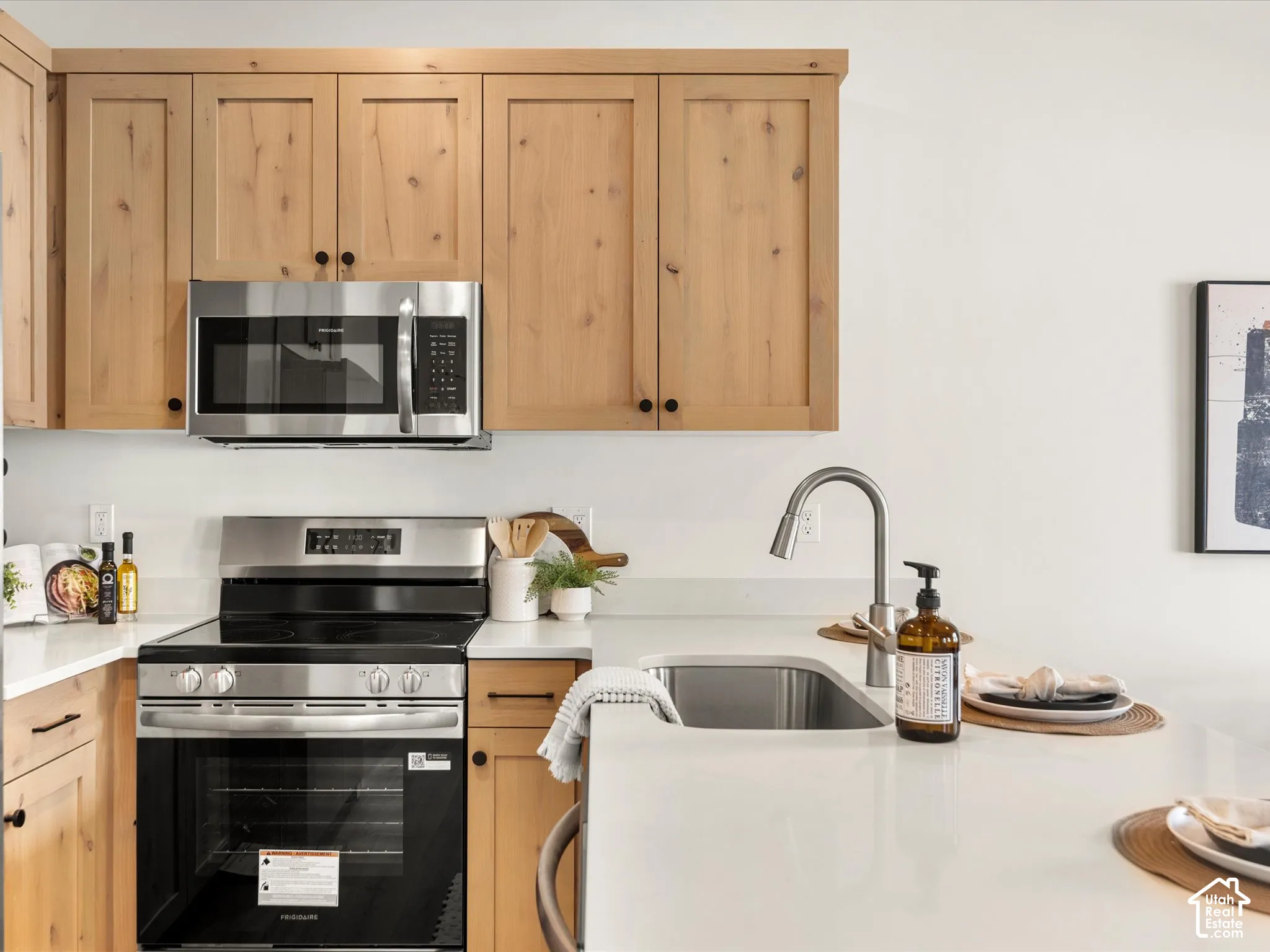 Wood-finish cabinetry, stainless steel appliances, and white countertops