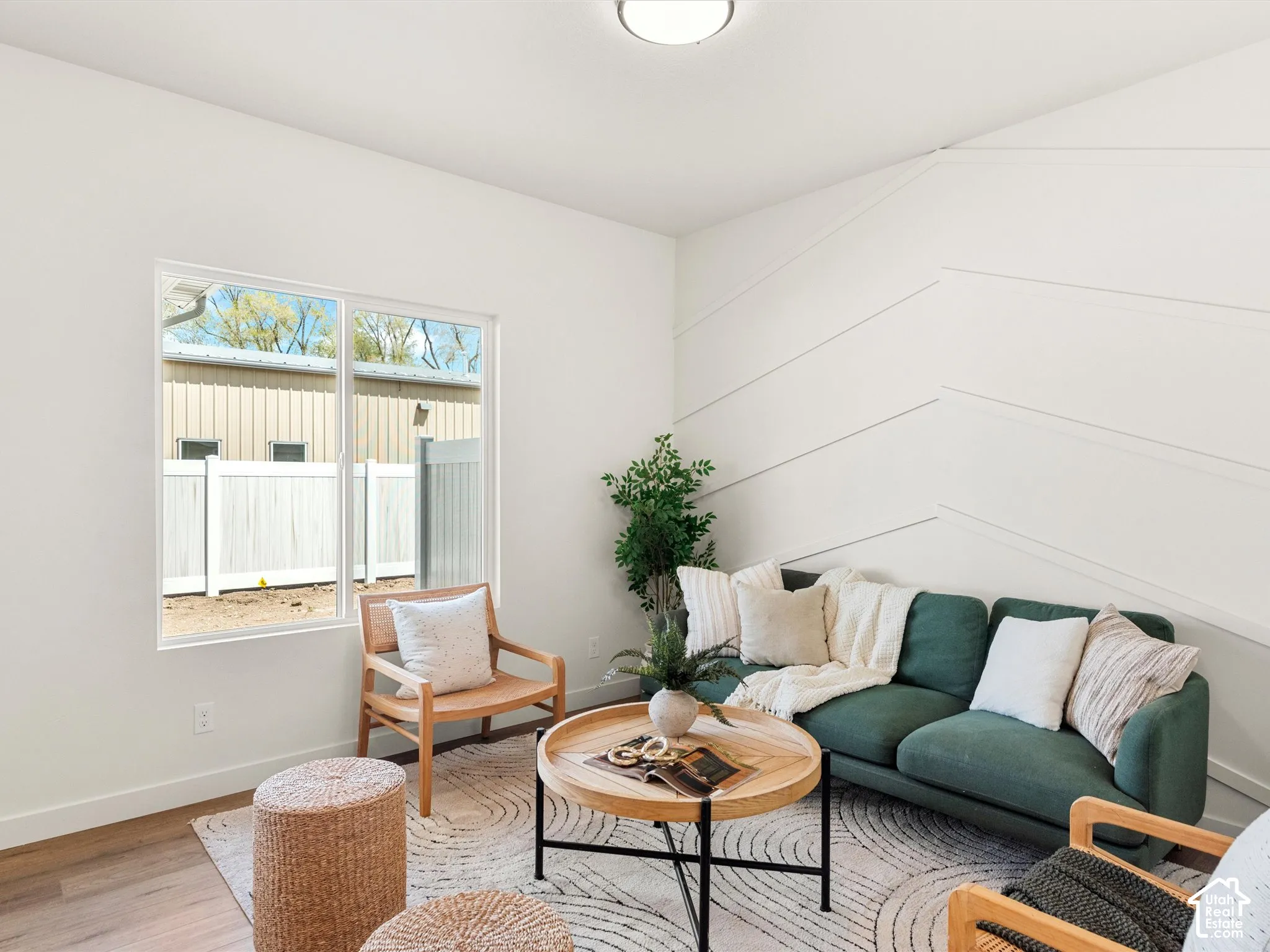 Geometric accent wall, wood-finish flooring, white walls, and a recessed ceiling light