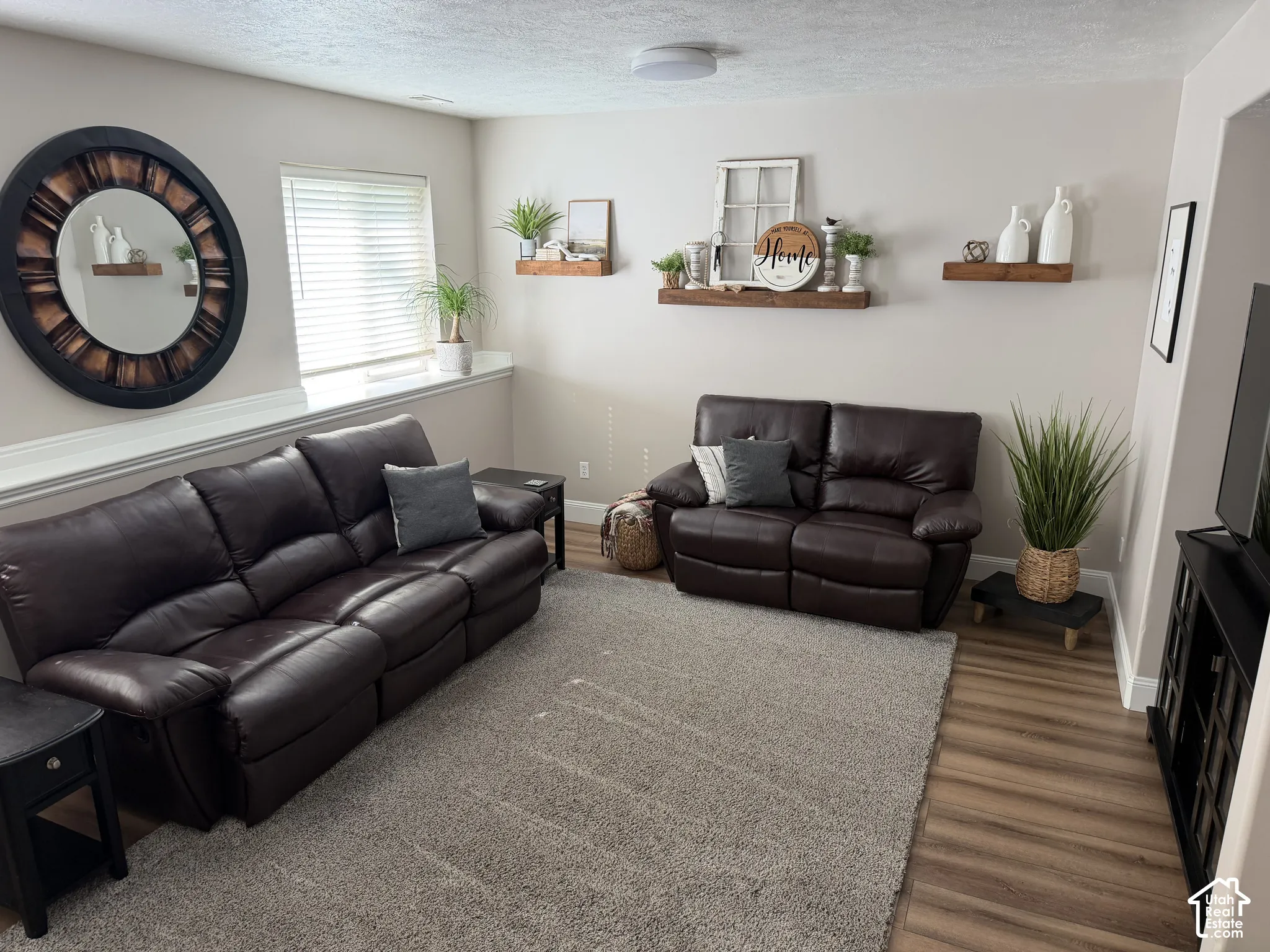 Recessed ceiling lighting, wood-finish flooring, light-toned wall paint, and a large window with blinds