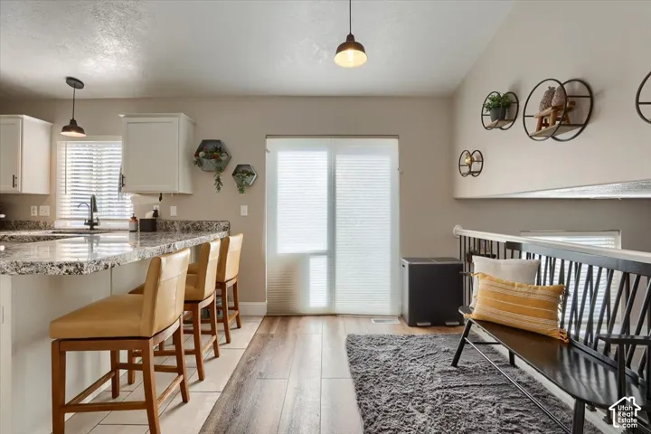 Kitchen island with a light-toned granite countertop and white cabinetry