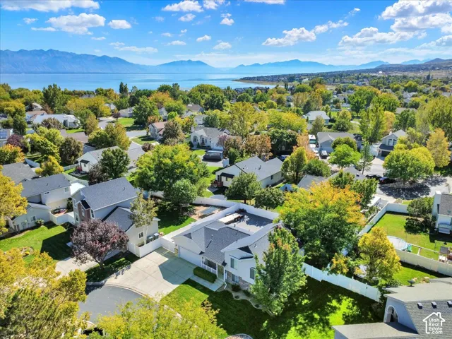 Aerial perspective showcasing a residential neighborhood with a large body of water and mountains in the background