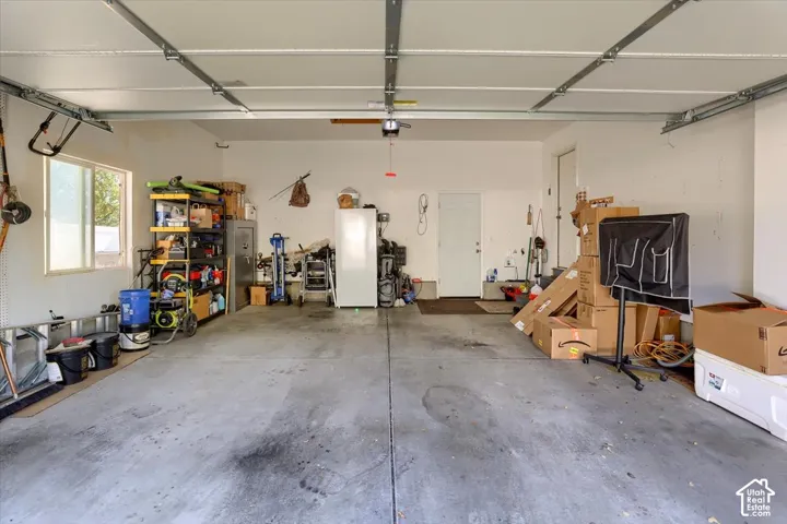 Garage with concrete flooring, white walls, and a window for natural illumination
