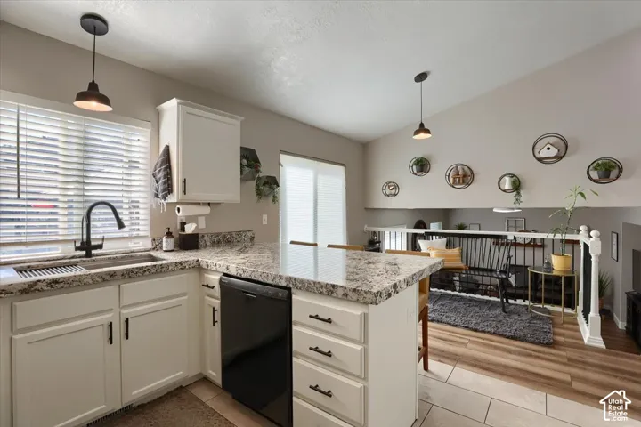 Kitchen featuring white cabinetry, stone-look countertops, and a black faucet with coordinating hardware