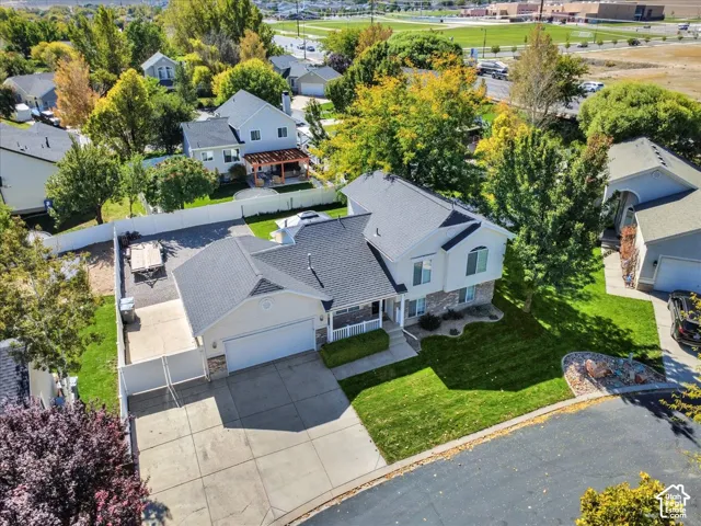 Two-story residence with a front-facing garage, concrete driveway, and mature landscaping