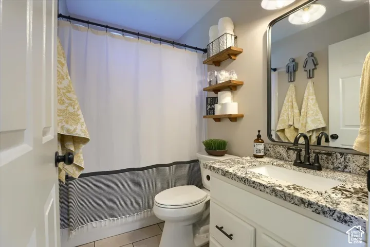 Spa-inspired bathroom featuring a white vanity with speckled quartz countertop, dual-handle faucet, and ample storage