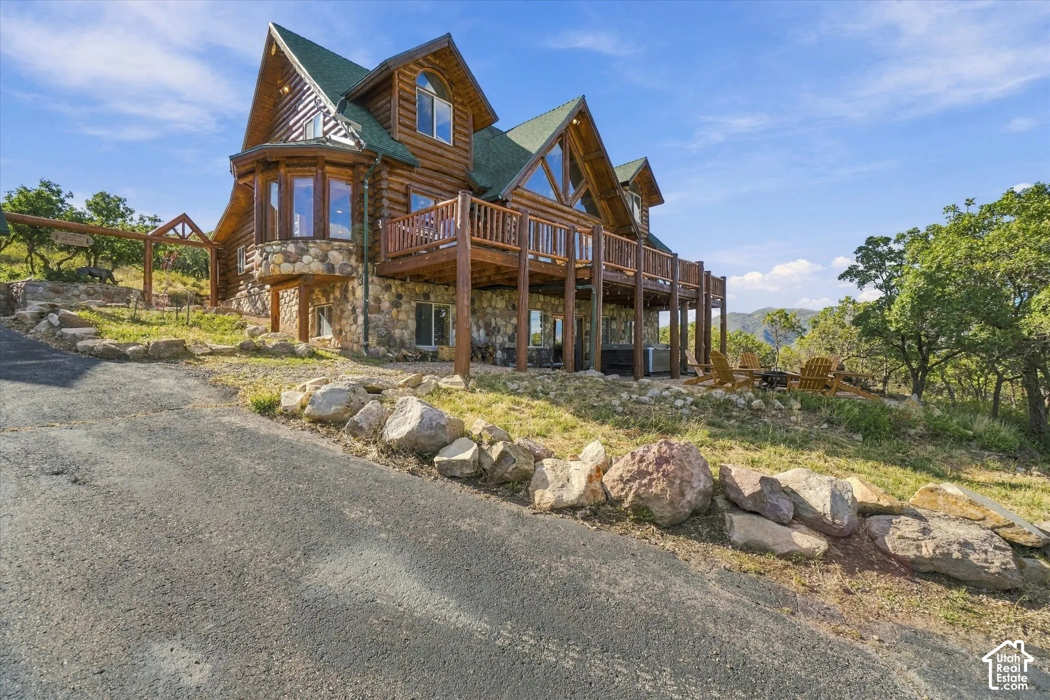 Log and stone exterior featuring multiple gables and a multi-level deck