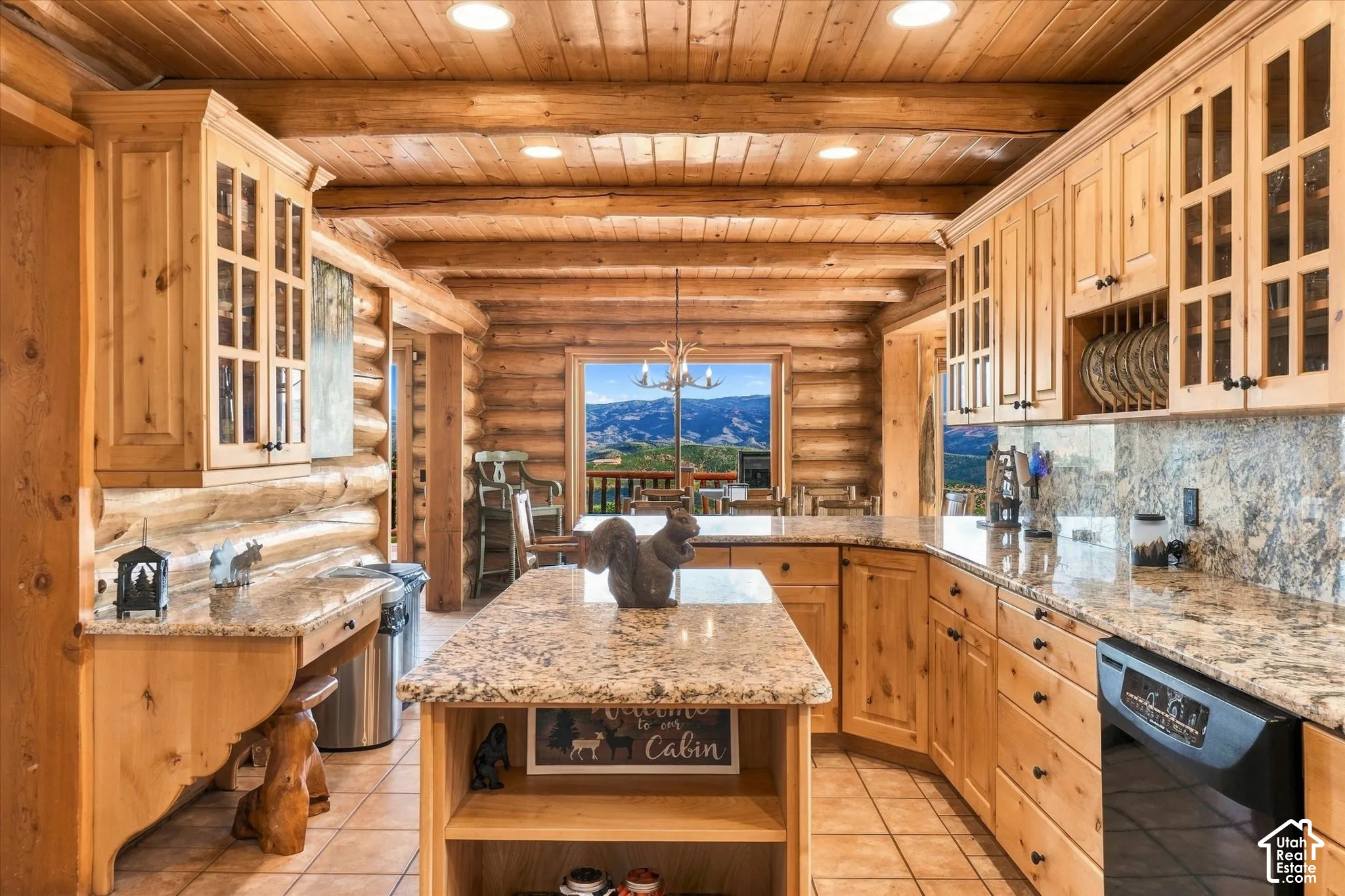 Kitchen featuring extensive light wood cabinetry, stone-finish countertops, and a central island