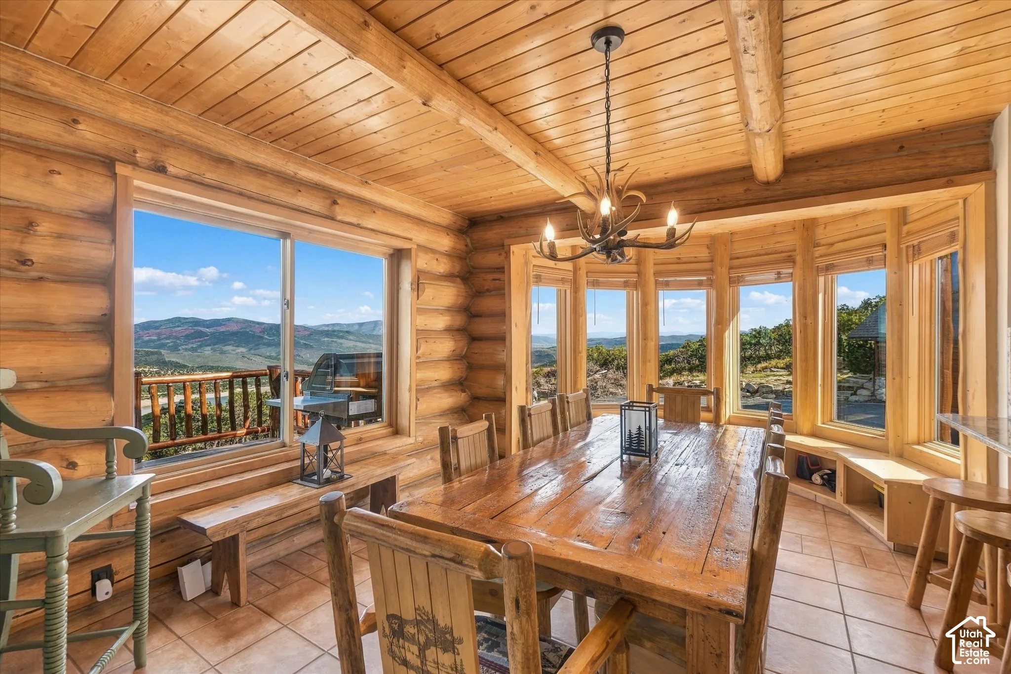 Extensive log wall construction, natural wood plank ceilings, tiled flooring, built-in window seating, and a multi-pane bay window