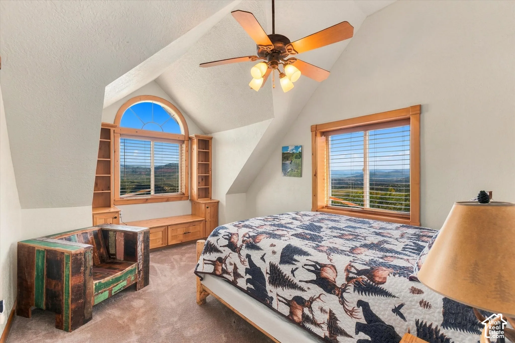 Arched window with built-in shelving, vaulted ceiling, and wood-finish window frames