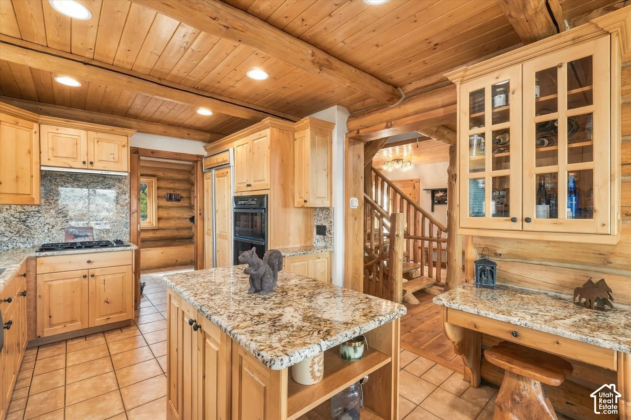 Kitchen featuring wood-finish cabinetry, granite countertops, tile flooring, and integrated appliances