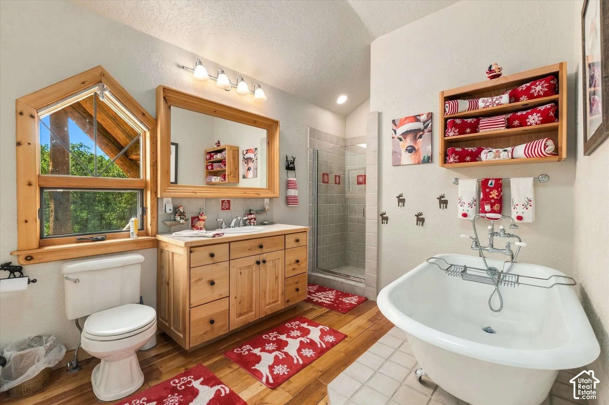 Wood-finish flooring, a freestanding bathtub, and a glass-enclosed shower