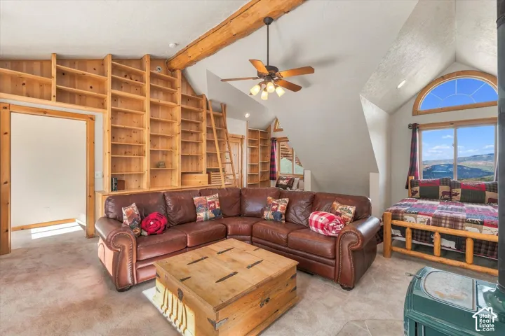 Built-in wood shelving with a rolling ladder, exposed wood beam ceiling, and a ceiling fan