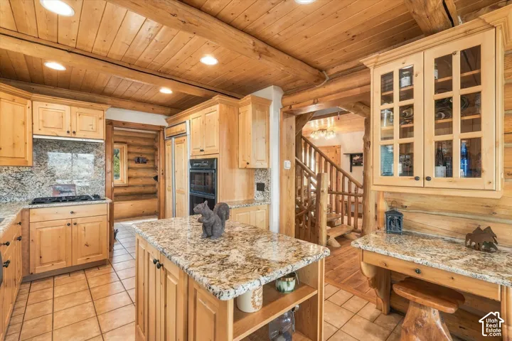 Kitchen featuring wood-finish cabinetry, granite countertops, tile flooring, and integrated appliances