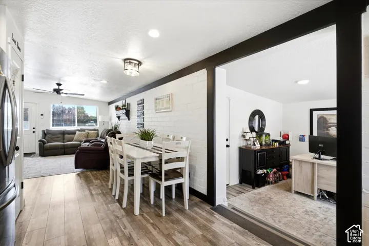 Wood-finish flooring with a white brick accent wall