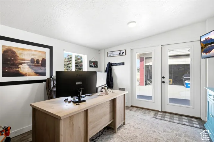 Recessed ceiling light, dual pane glass panel doors, wood-finish flooring, white walls, and a window with blinds