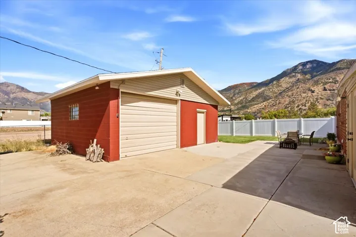 Detached garage with a roll-up door, red brick exterior, and light-colored siding