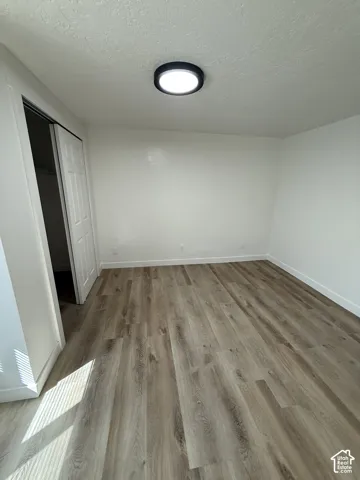 Recessed ceiling light fixture, wood-finish flooring, and white painted walls