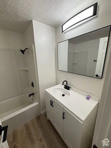 White vanity with a single basin sink, matte black faucet, and white countertop
