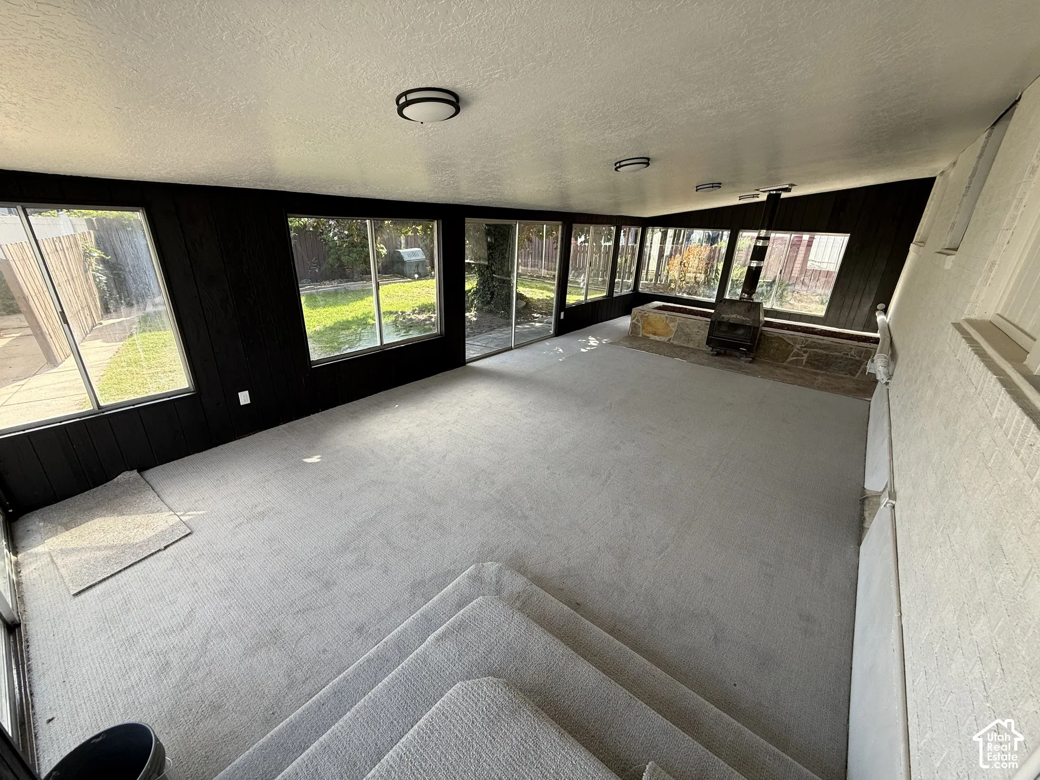 Recessed living area with light-toned carpeting and wood-burning stove