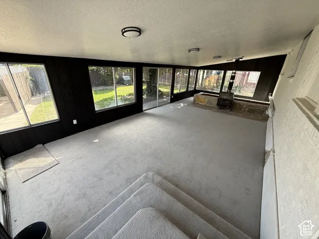 Recessed living area with light-toned carpeting and wood-burning stove