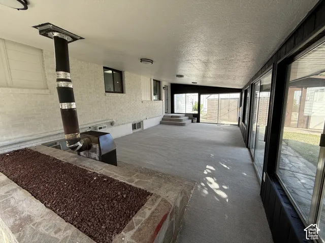 Expansive enclosed patio with sliding glass panels and integrated wood-burning stove