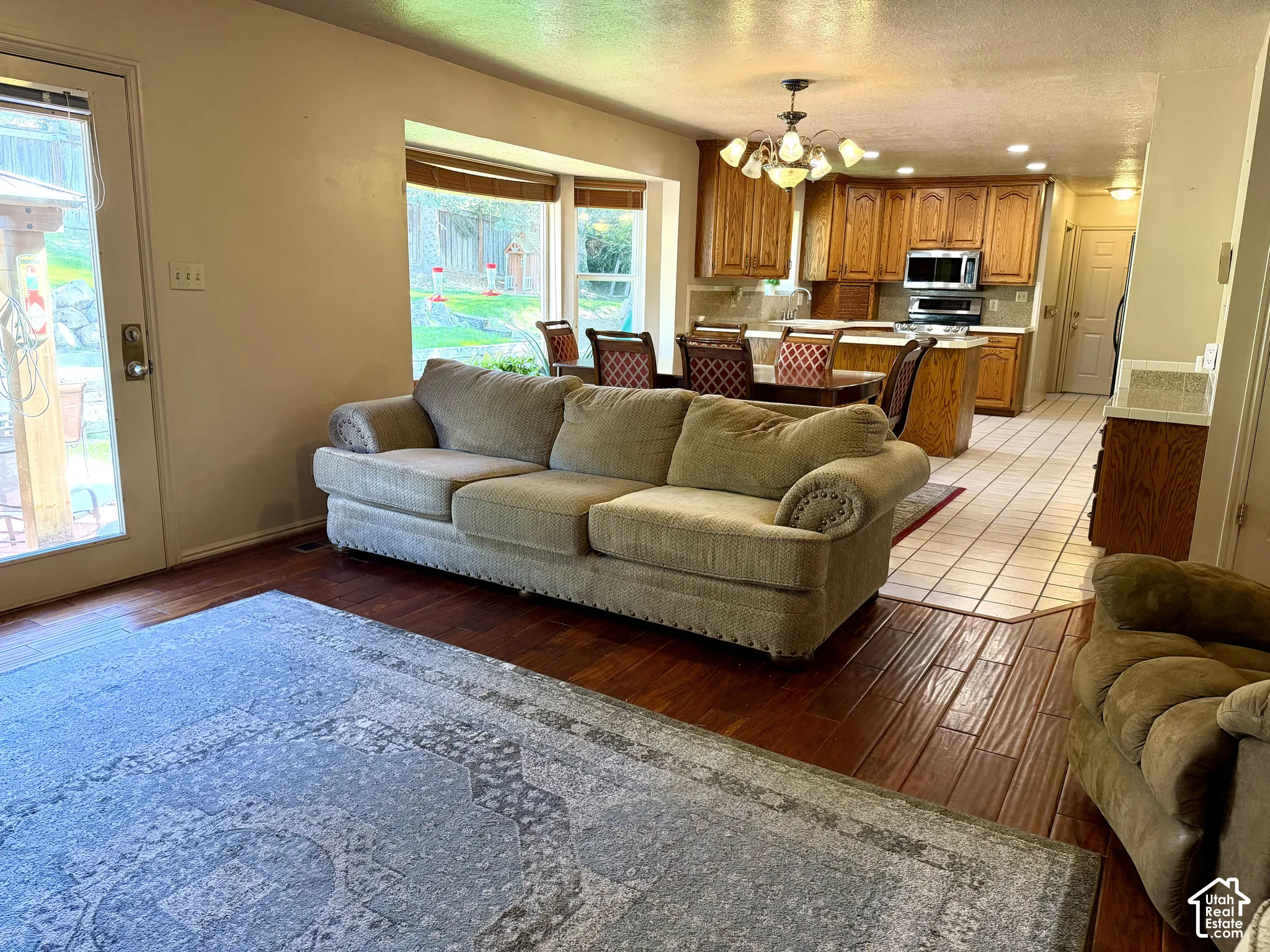 Hardwood-finish flooring, bay windows, wood cabinetry, tile flooring, and a glass-paneled door